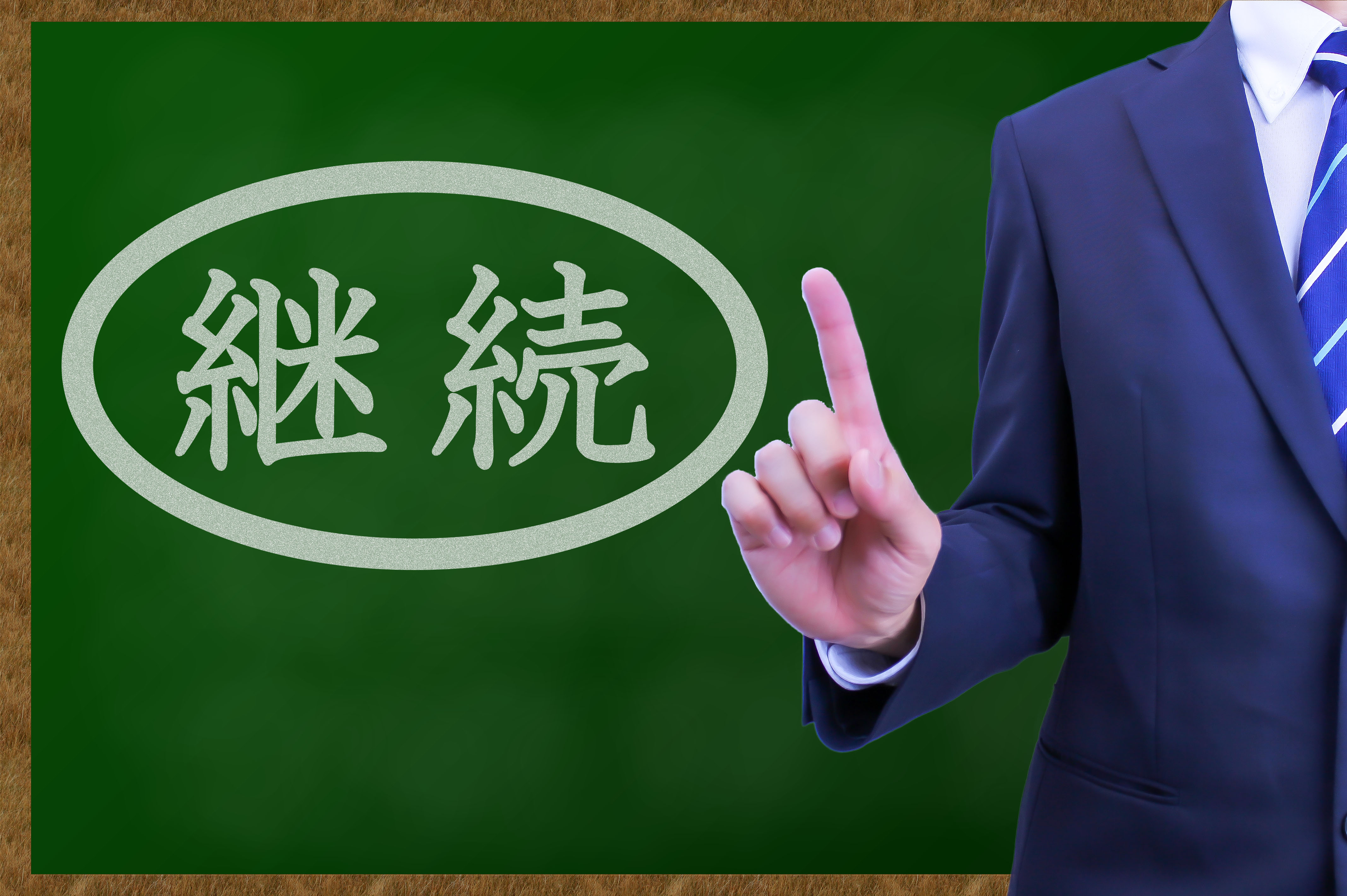 インハウスSEOを成功させるコツとして、黒板に書かれた「継続」の文字を指し示し、運用の大切さを強調する様子。