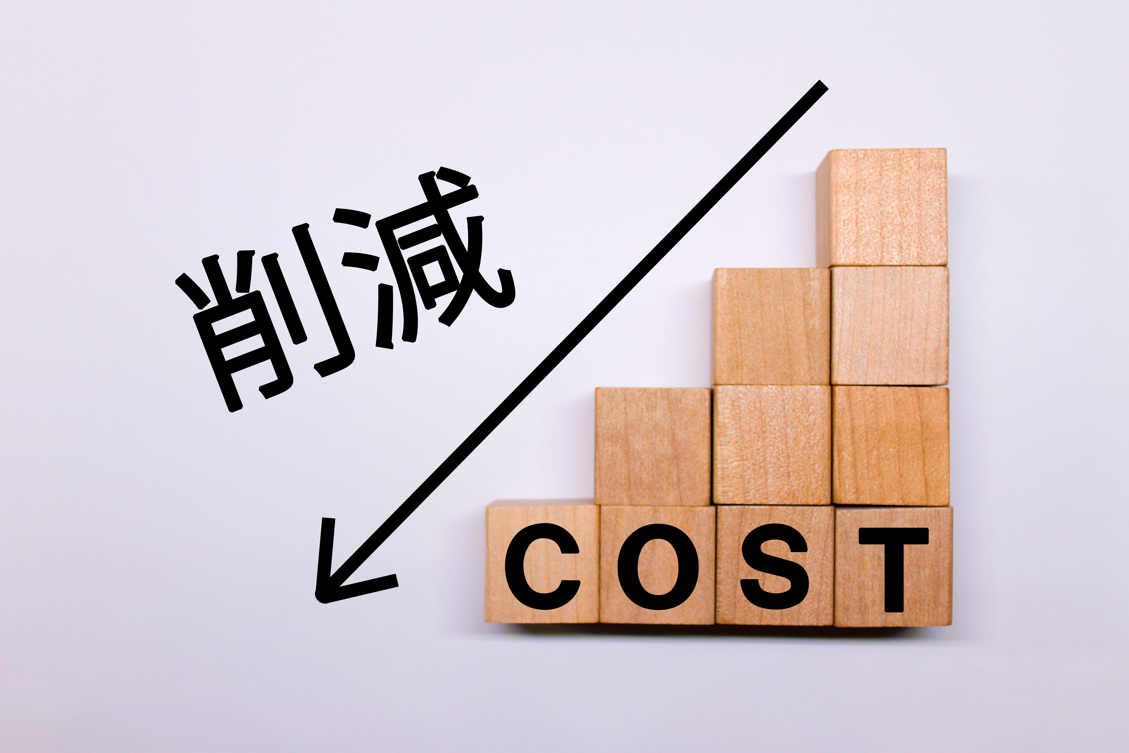 インハウスSEOによるコスト削減のメリット。積み木に書かれたCOSTの文字と、右肩下がりの削減を表す矢印。