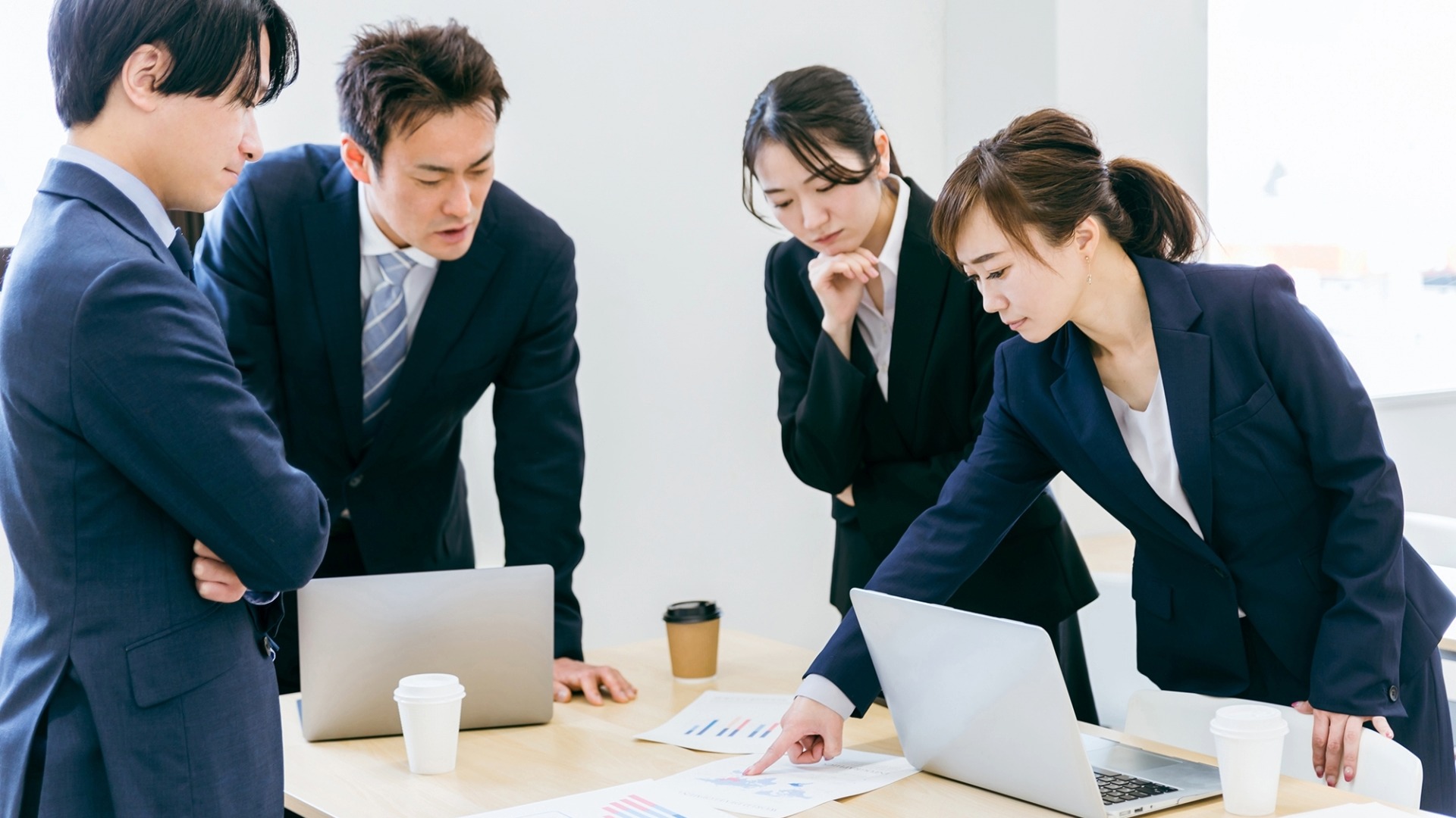 オウンドメディア運用の目的について話し合うチームミーティング。具体的なデータに基づき失敗原因を分析する様子。