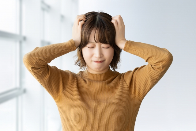 被リンク獲得やSEO対策の課題に直面し、頭を抱えて悩む女性