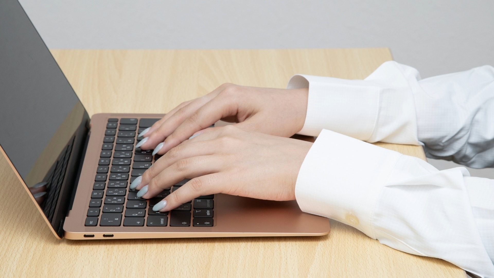 オウンドメディアの記事執筆手順に従って、ノートPCでタイピングを行うWebライターの手元。