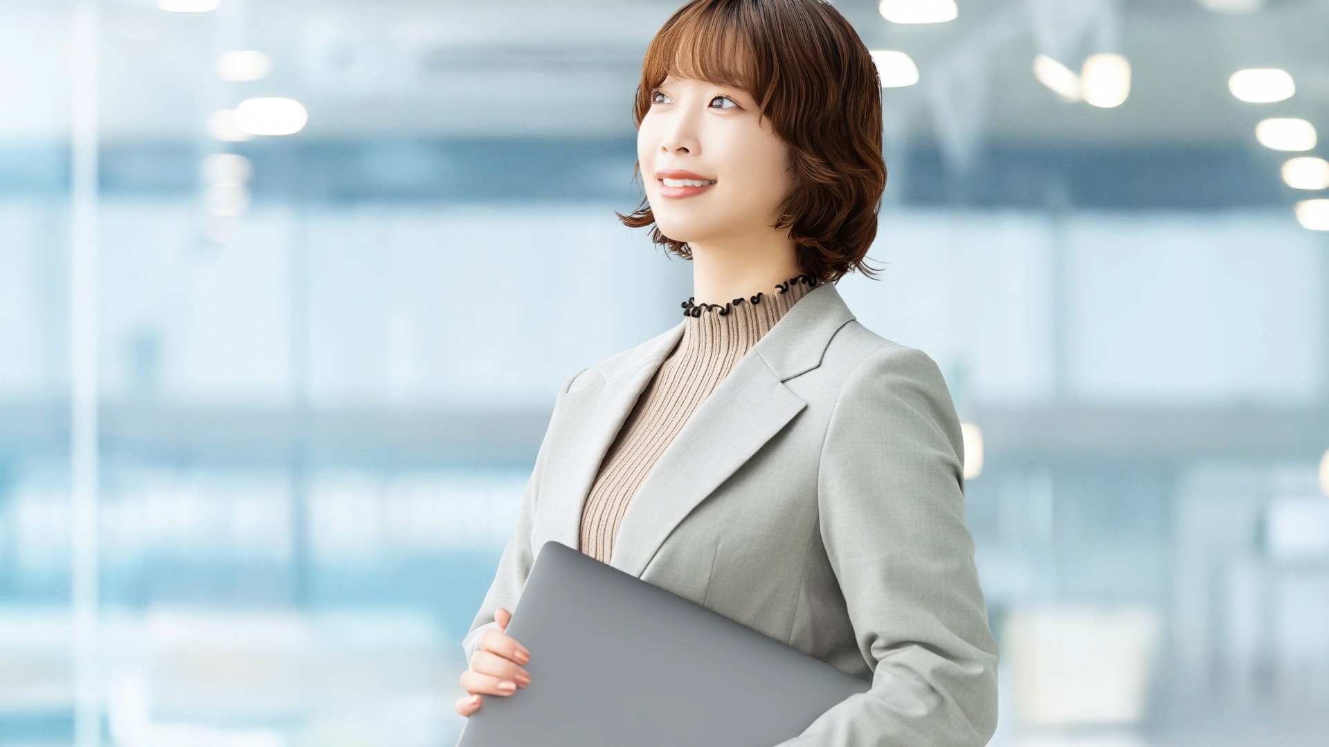 オウンドメディア構築のメリットや将来のビジョンを構想する、スーツ姿の女性Web担当者。