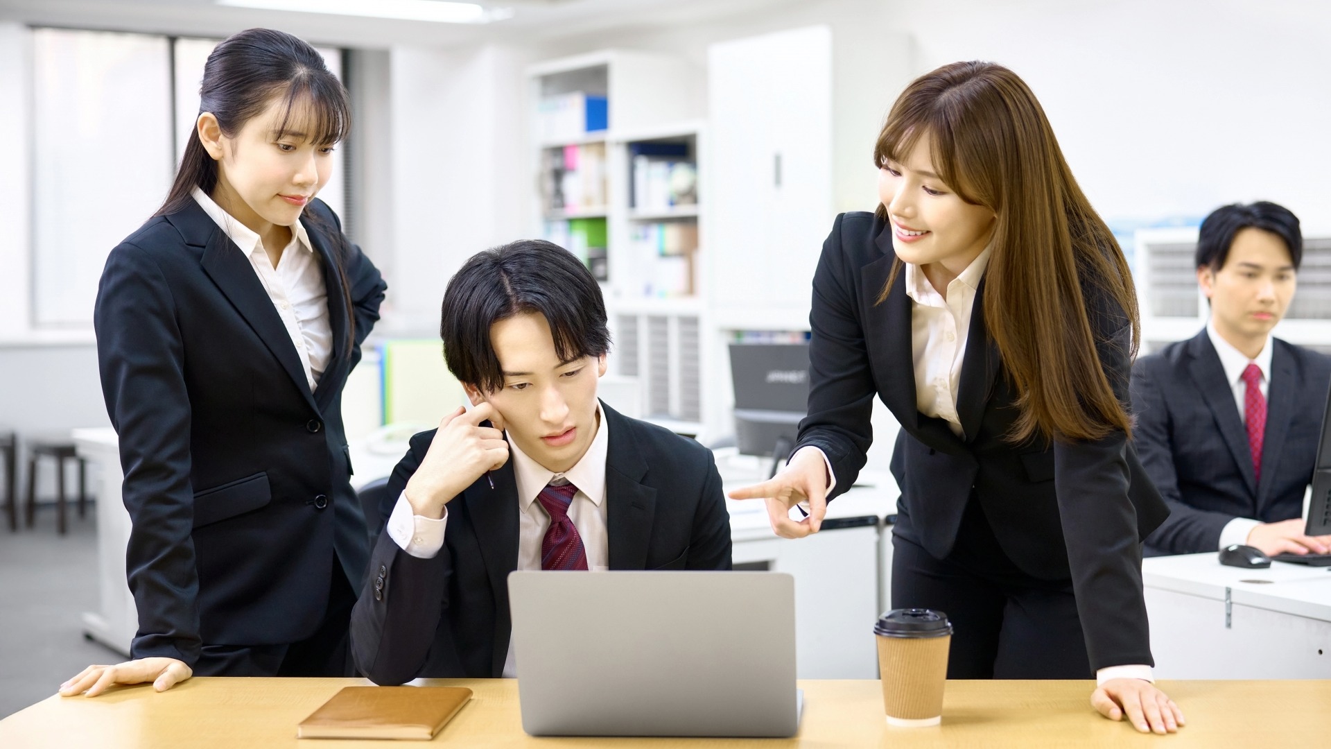 オウンドメディア構築の手順を指導するディレクターと、指示を受ける実務スタッフの打ち合わせ。