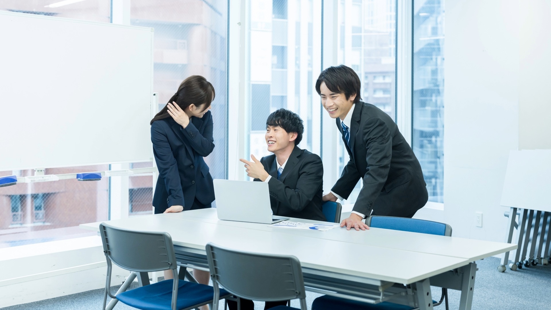 オウンドメディアの成功事例を共有し、明るい雰囲気でミーティングを行うプロジェクトチーム。