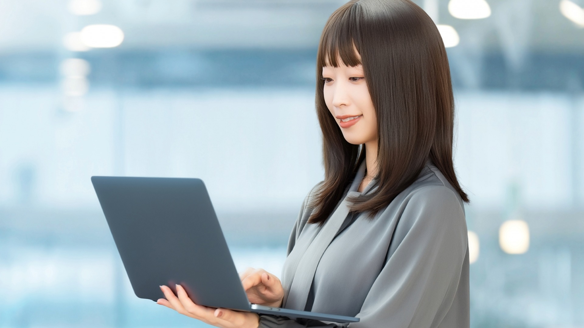 オウンドメディアの構築手順を確認しながら、ノートPCでサイトのデザインや設定を操作する女性。