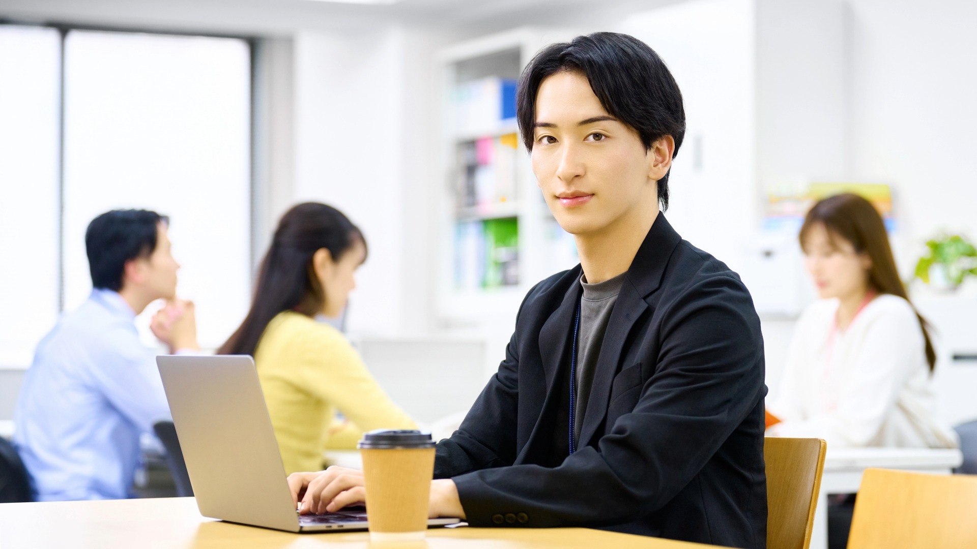 オウンドメディア運用の社内体制を整え、ノートPCで記事を執筆する若手編集スタッフ。