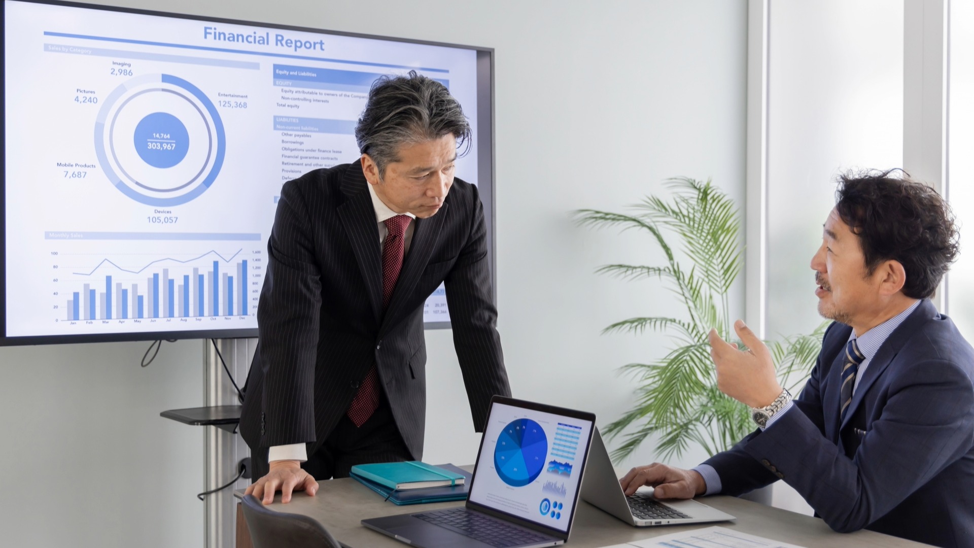 大型モニターに表示された詳細な解析データに基づき、オウンドメディアの最終的なKPI(KGI)について議論する経営層。