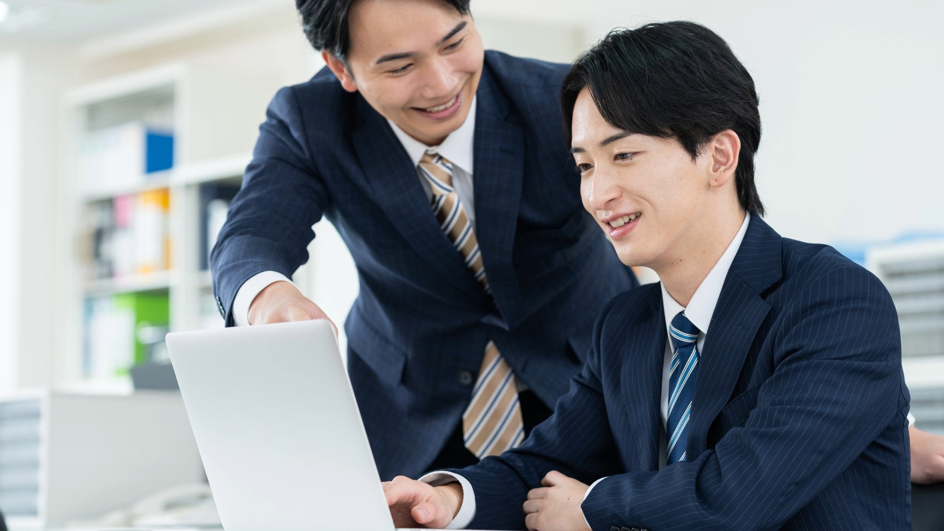 オウンドメディアのアクセス解析結果を共有し、KPI達成のポイントを解説する上司と部下。