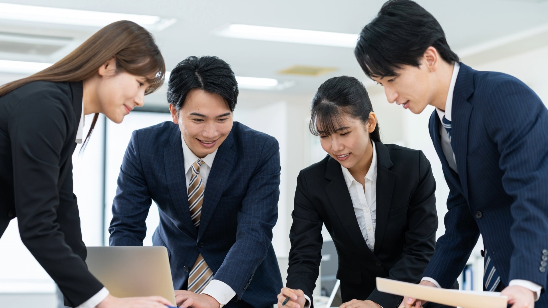 オウンドメディアの適切なKPI設定のために、チームで熱心に議論するマーケティング担当者たち。