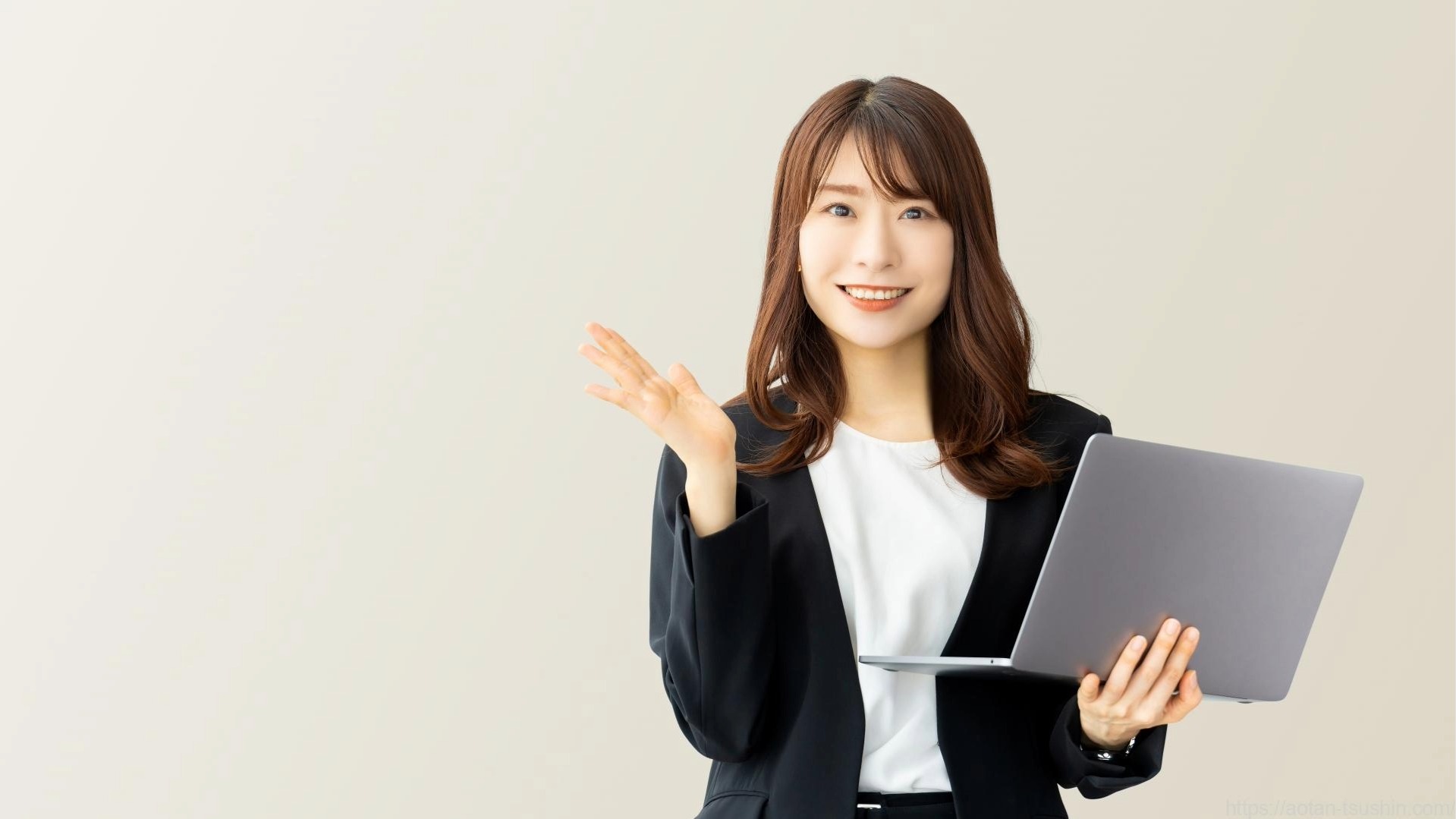 PCを片手にオウンドメディア運用に関する質問に答える女性のイメージ。