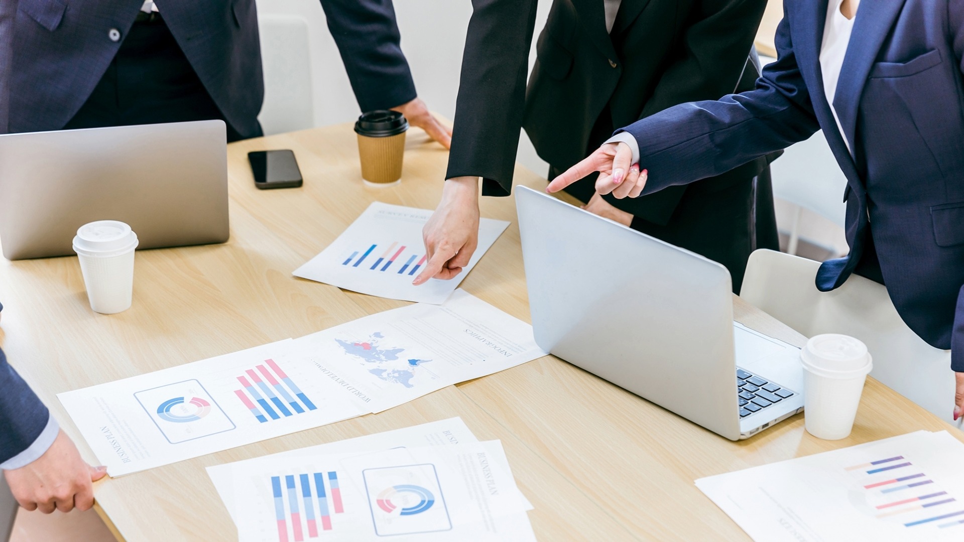 SEO外部対策の会議で被リンク獲得の戦略やデータ分析資料を共有するビジネスチーム。