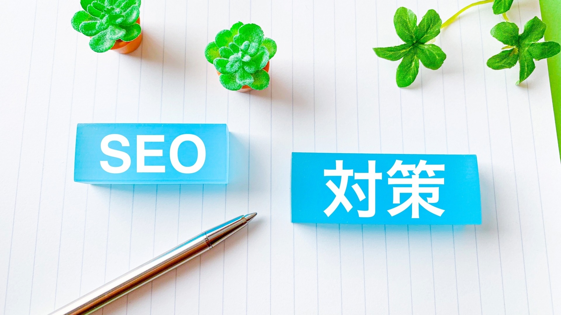 オウンドメディアを成長させるための具体的な「SEO対策」をテーマにした、清潔感のあるデスクワークのイメージ