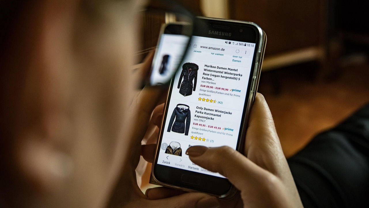 オウンドメディアの目的の一つである、購買意欲の向上とECサイトへの誘導を表現したイメージ。スマートフォンで商品を比較検討する現代の消費者の購買行動。