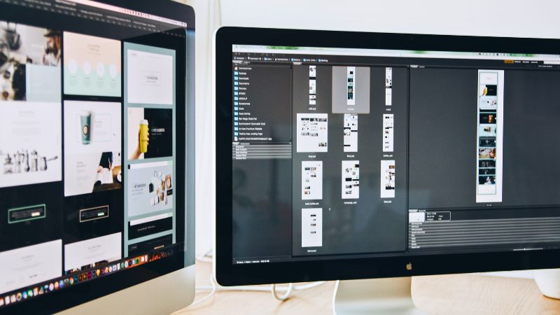 オウンドメディアの資産性を高める質の高いデザイン制作。複数のモニターを使い、サイト構成やビジュアル素材を細かく編集・管理する様子。